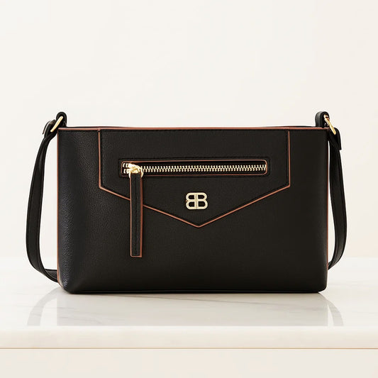 Cartera cruzada negra con bolsillo frontal, zipper dorado y correa colgante ajustable.