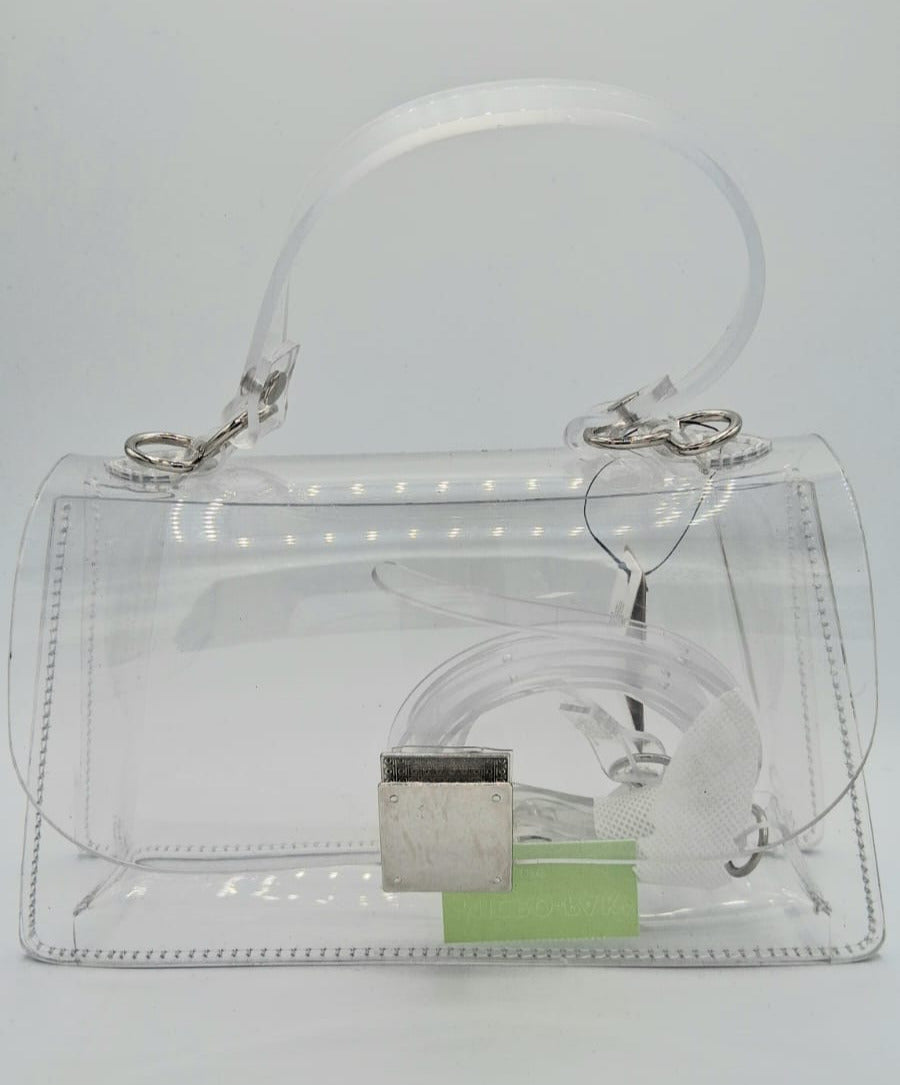 Cartera transparente rígida con cierre plateado y correa larga removible.