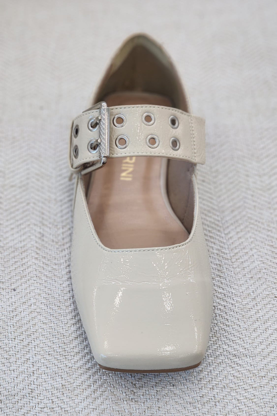 Vista frontal de zapato plano elegante off white con punta cuadrada.