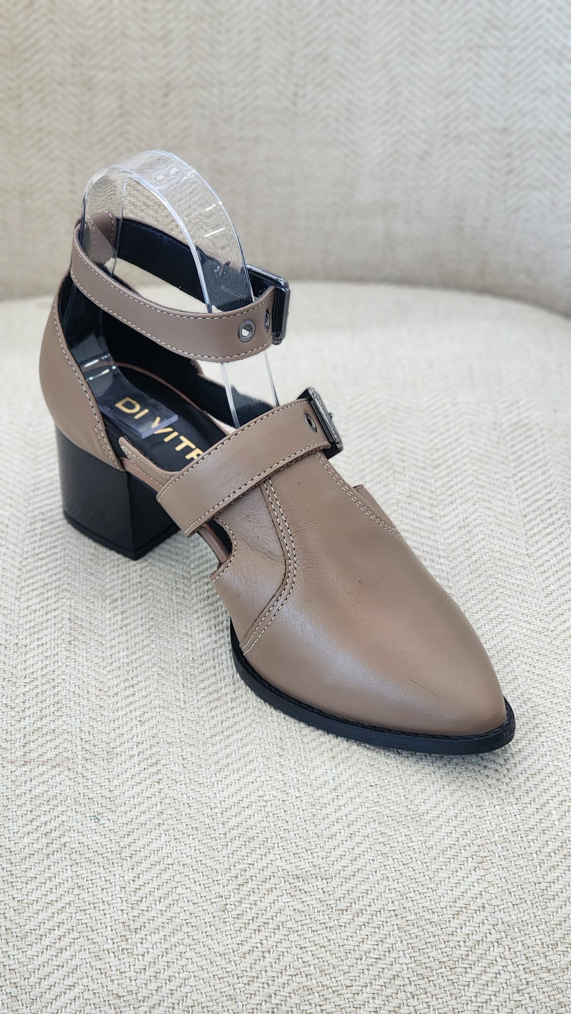 Zapato beige de tacón bloque medio con punta afilada y doble correa con hebillas metálicas.